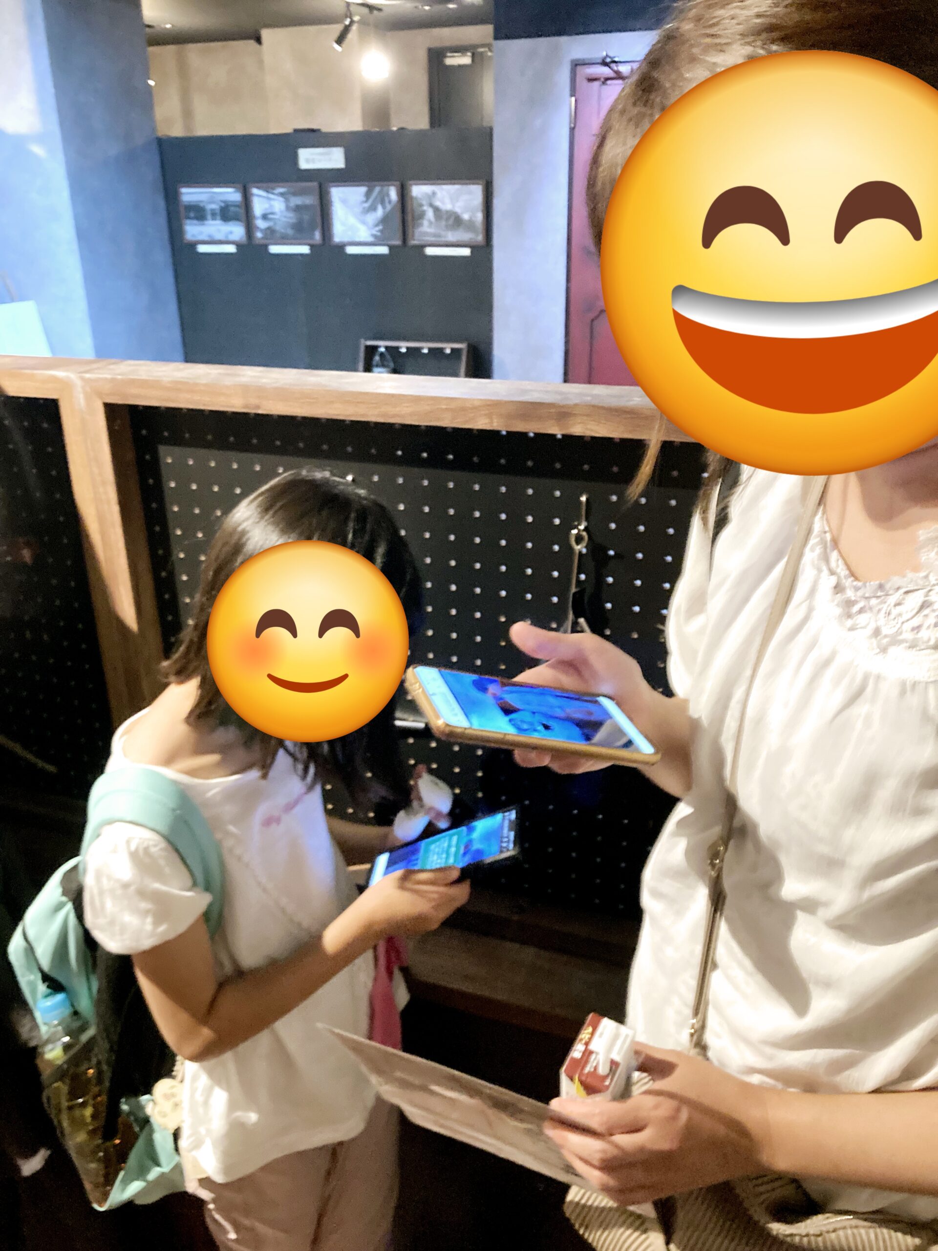 壁のヒントとスマホを見比べる親子